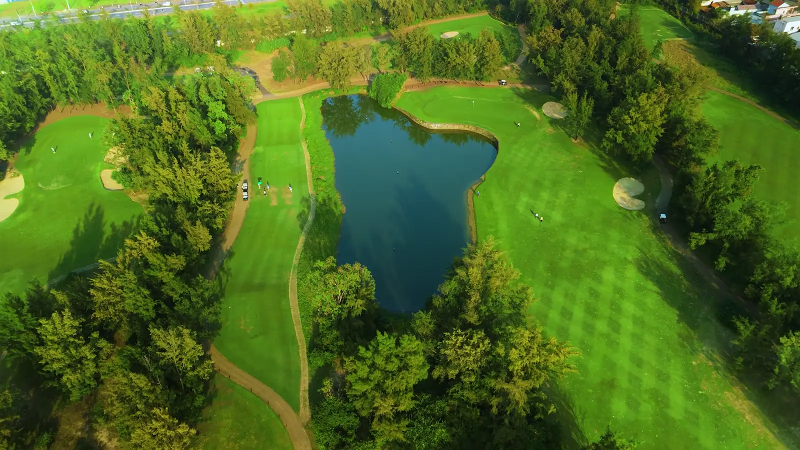 Aerial panorama over a manicured golf course with fairways, bunkers and greens