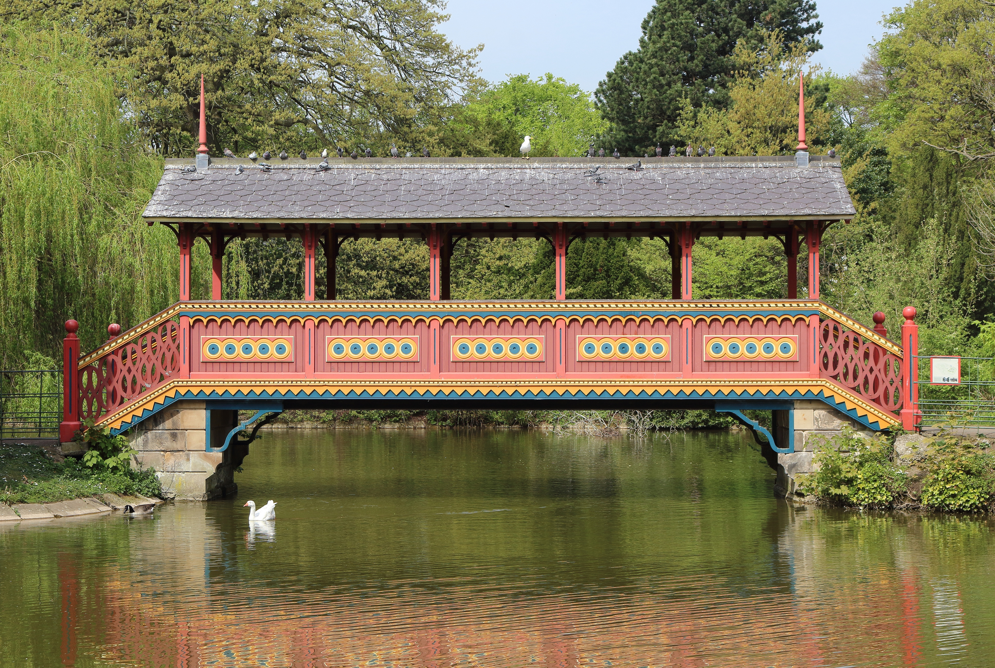 The red Swiss Bridge over the lake in Birkenhead Park