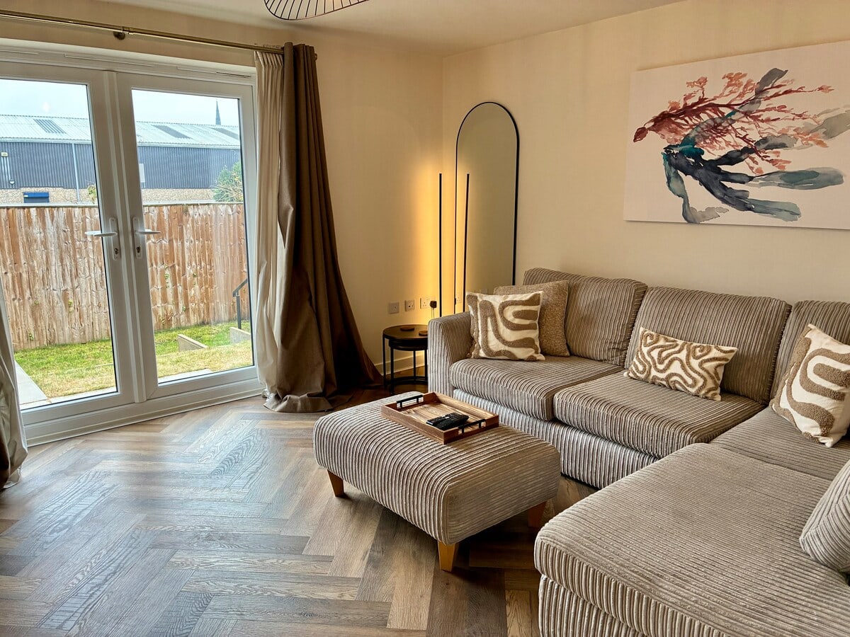 Fairwater House lounge with corner sofa and doors to the garden
